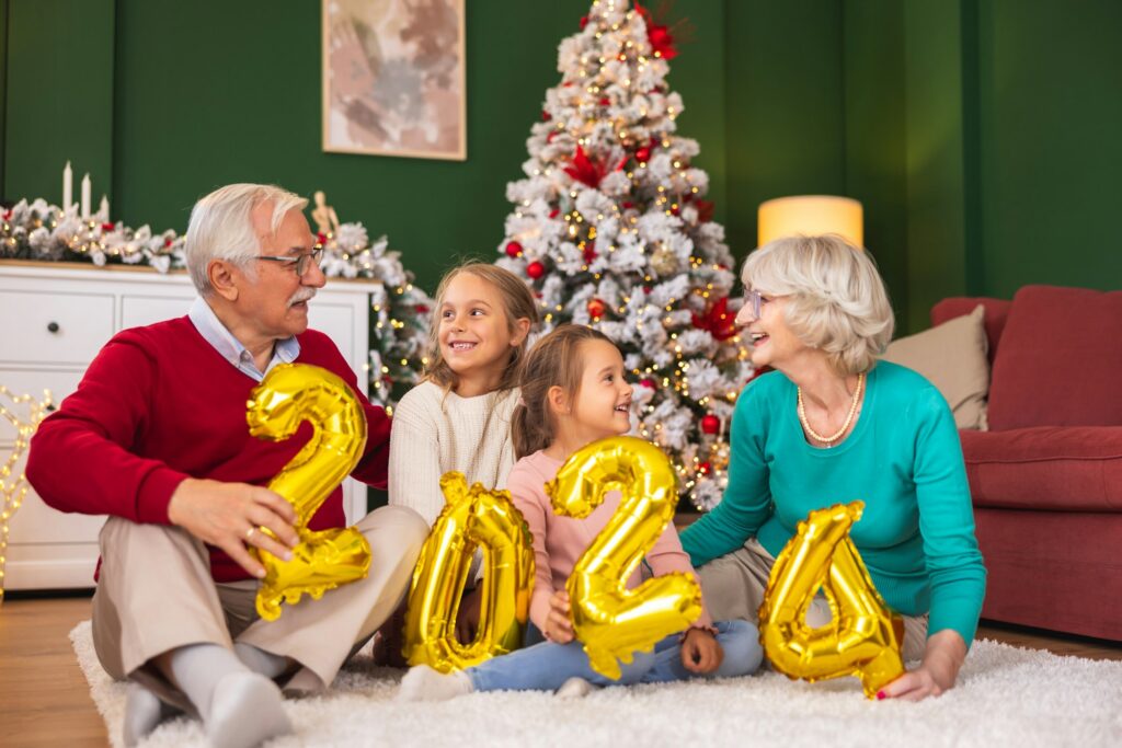 Grandparents celebrating New Year with grandchildren holding 2024 balloons