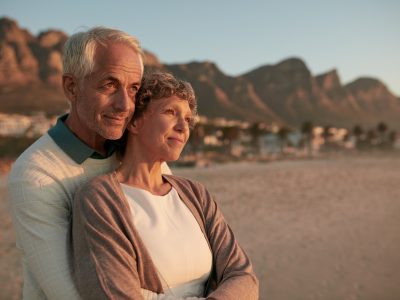 Elderly couple standing together and embracing on the beach
